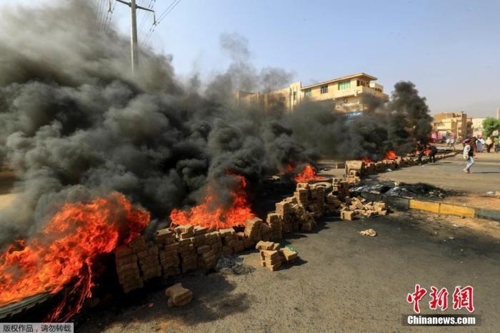 當?shù)貢r間10月25日，蘇丹局勢發(fā)生突變，過渡政府總理被“綁架”，政府部長被軍方抓捕，國家進入緊急狀態(tài)，大量民眾走上街頭對軍方行動進行抗議，已有7人在抗議活動中死亡，140人受傷。圖為抗議活動中燃燒的輪胎。