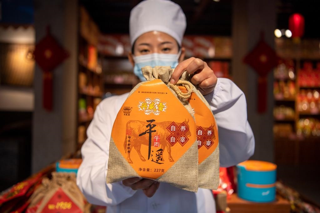 1月27日，在平遙古城南大街的一家平遙牛肉店內(nèi)，工作人員展示一款牛肉產(chǎn)品。新華社記者 楊晨光 攝