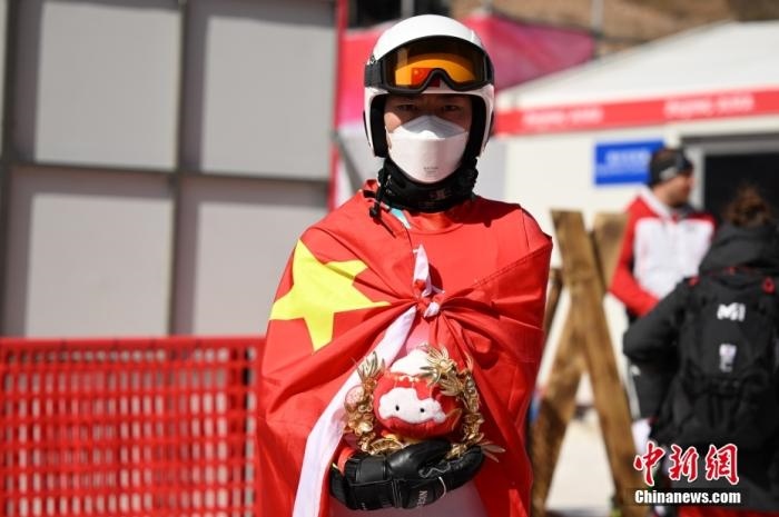 3月6日，中國選手梁景怡在賽后手捧吉祥物。當日，北京2022年冬殘奧會殘奧高山滑雪男子超級大回轉-站姿決賽在國家高山滑雪中心舉行，中國選手梁景怡奪得冠軍。 <a target='_blank' href='/'>中新社</a>記者 劉冉陽 攝 　