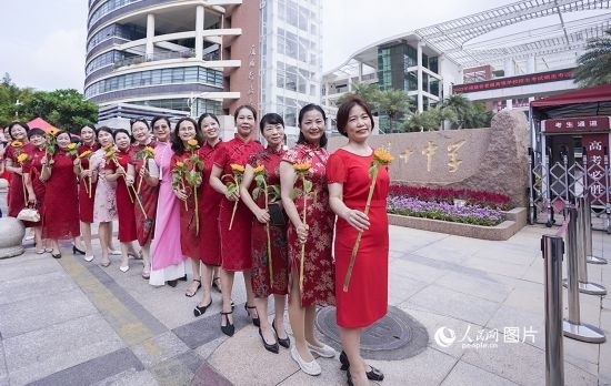 6月7日一早，廈門(mén)雙十中學(xué)考生家長(zhǎng)們身穿旗袍，手拿向日葵在考場(chǎng)外為孩子加油打氣，寓意“旗開(kāi)得勝，一舉奪魁”。人民網(wǎng)記者 陳博攝