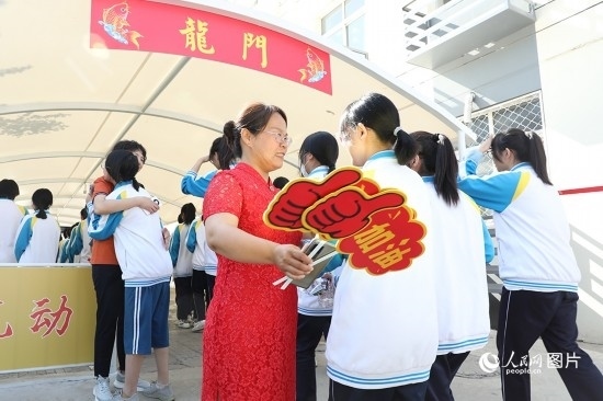 6月7日一早，雄安新區(qū)安新中學(xué)老師在給同學(xué)們加油鼓勁兒。人民網(wǎng) 李兆民攝