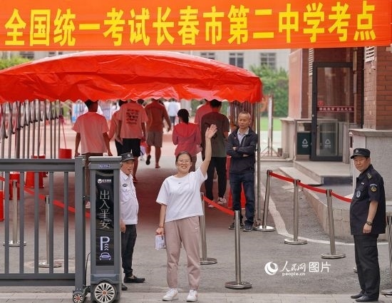 6月7日，在長(zhǎng)春市第二中學(xué)考點(diǎn)，一名考生信心滿(mǎn)滿(mǎn)進(jìn)入考場(chǎng)，并與家長(zhǎng)揮手致意。人民網(wǎng)記者 李洋攝