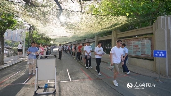 6月7日，烏魯木齊市第七十中學(xué)門(mén)口，考生們有序進(jìn)入考場(chǎng)。人民網(wǎng) 李欣洋攝