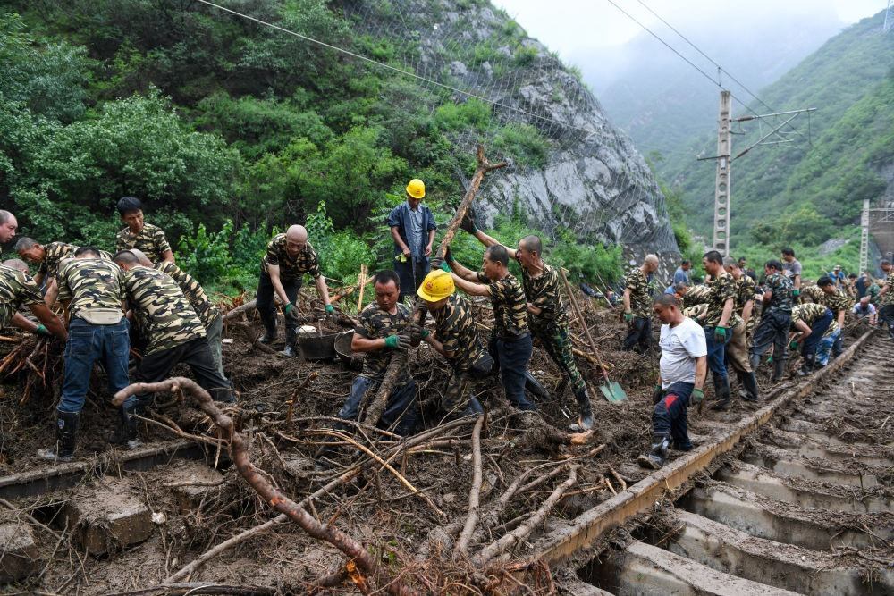 8月1日，在北京市門頭溝區(qū)水峪嘴村附近一段被阻斷的鐵路線上，中鐵六局工作人員在清理軌道上的雜物，全力恢復(fù)交通。新華社記者 鞠煥宗 攝