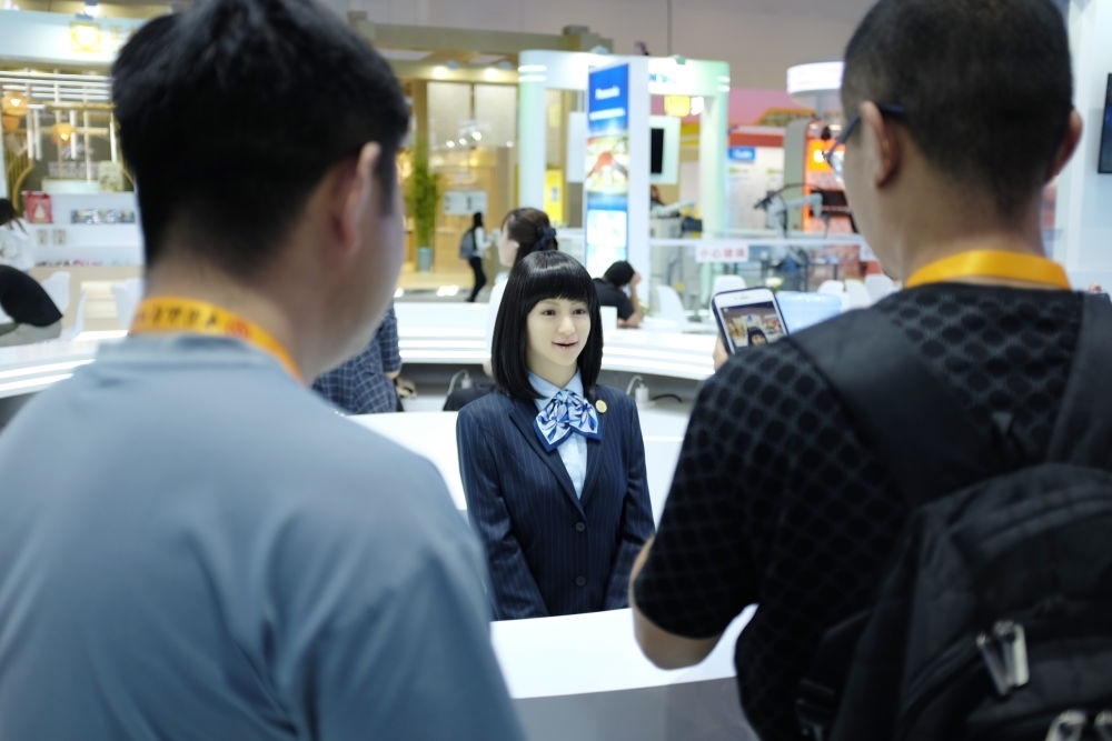 9月1日，媒體記者在國(guó)家會(huì)議中心與服務(wù)機(jī)器人互動(dòng)。新華社記者 劉夢(mèng)琪 攝