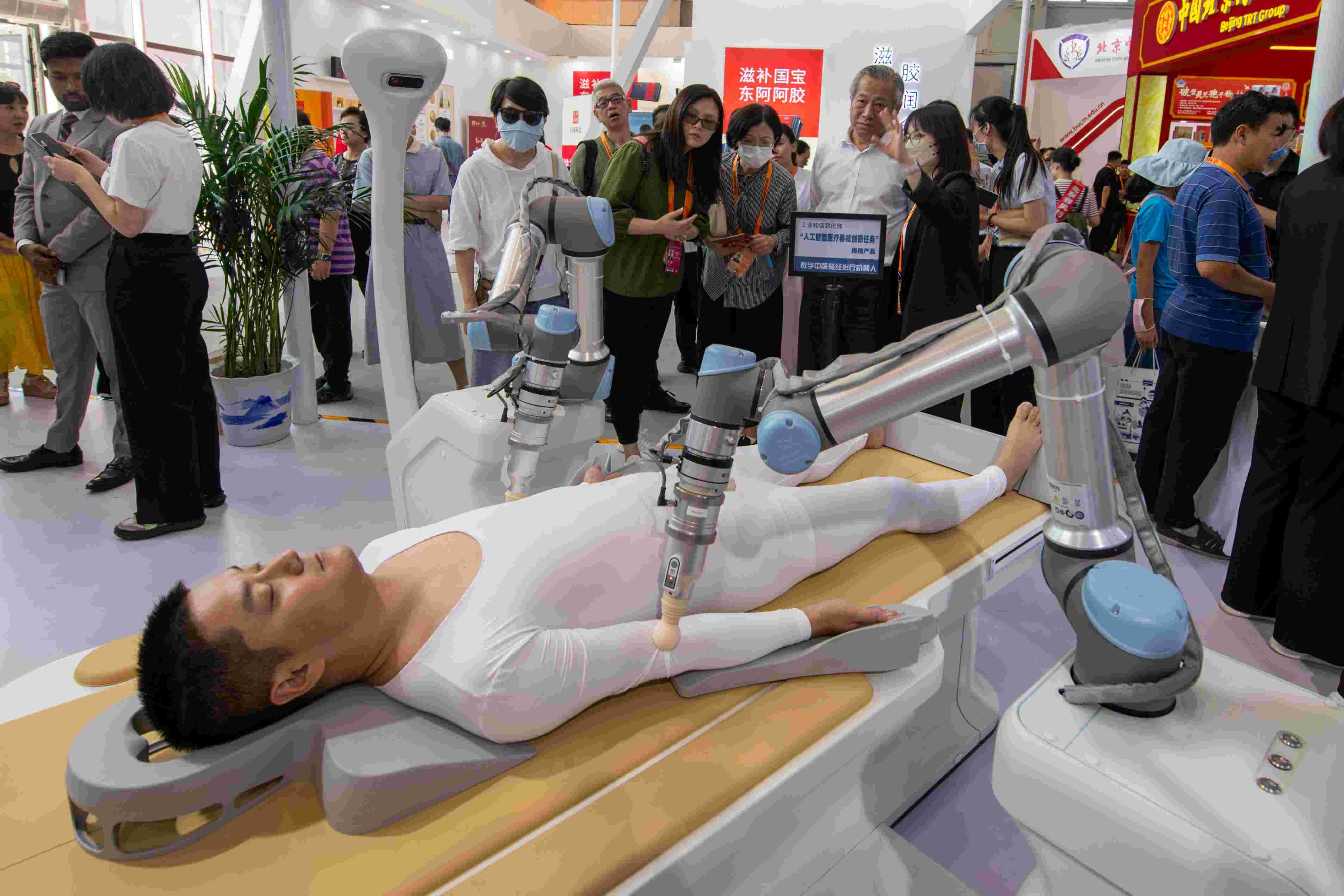 在位于首鋼園的健康衛(wèi)生服務展區(qū)，觀眾正在參觀數字中醫(yī)循經治療機器人。人民網記者 翁奇羽攝