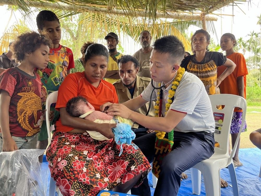 2023年8月5日，在巴布亞新幾內(nèi)亞中央省的一個村莊里，第12批援巴新中國醫(yī)療隊副隊長、新生兒科副主任醫(yī)師劉振球為當(dāng)?shù)貗雰郝犜\檢查。新華社發(fā)（第12批援巴新中國醫(yī)療隊供圖）