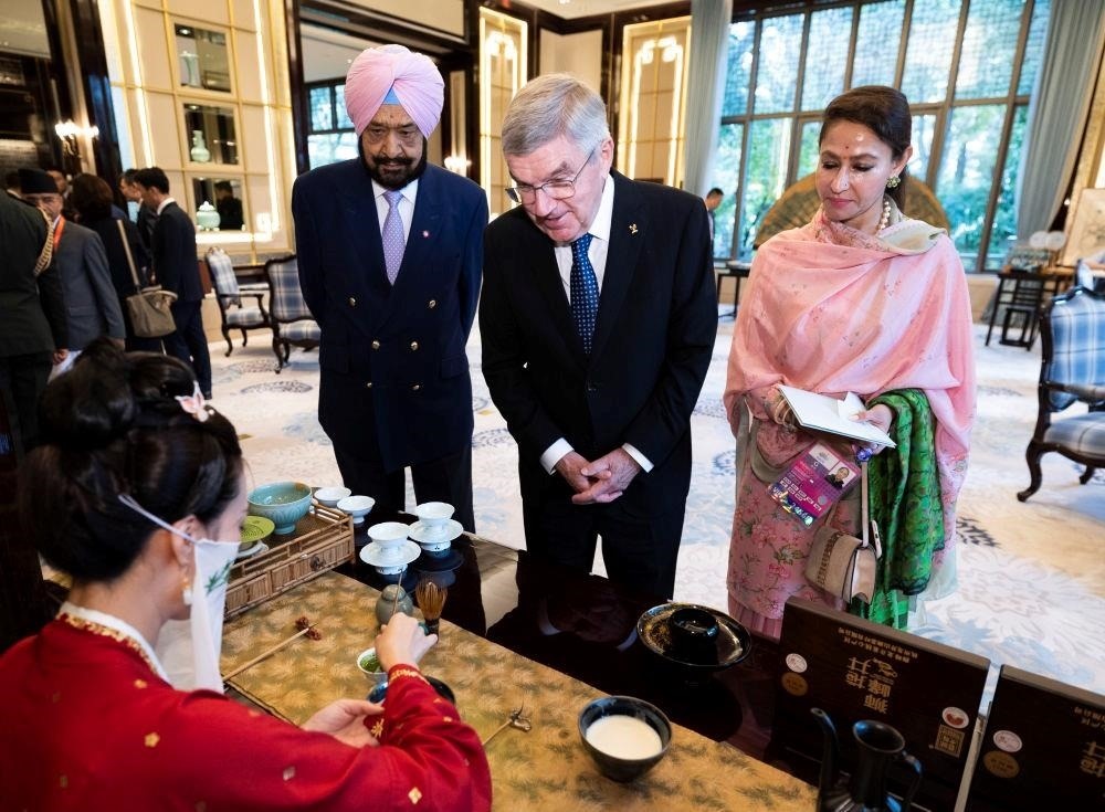 △歡迎宴會前，亞奧理事會代理主席辛格和夫人維尼塔、國際奧委會主席巴赫欣賞非遺展示。