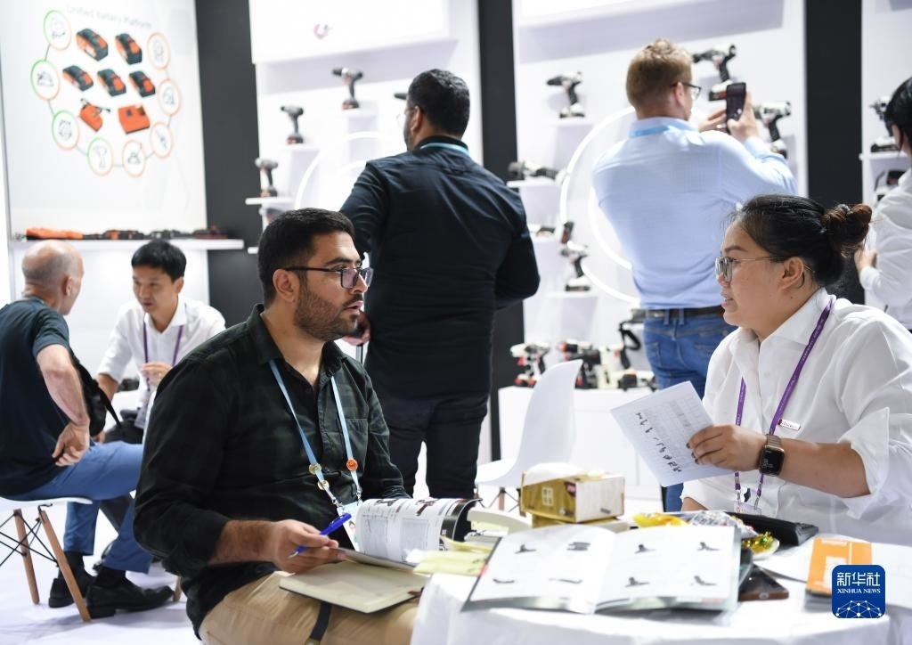 10月15日，在一家電動工具展臺，外國采購商在洽談業(yè)務。新華社記者 鄧華 攝