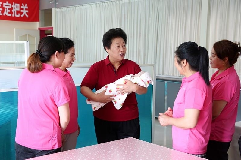 △2021年6月2日，卓長立（中）指導(dǎo)正在接受培訓(xùn)的家政服務(wù)員。