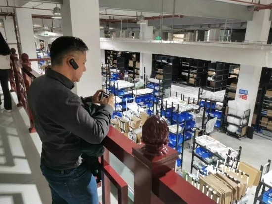 2023“一帶一路”媒體合作論壇聯(lián)合采訪團團員在仁和醫(yī)藥物流園拍攝記錄轉運流程。（本報記者 黃超攝）