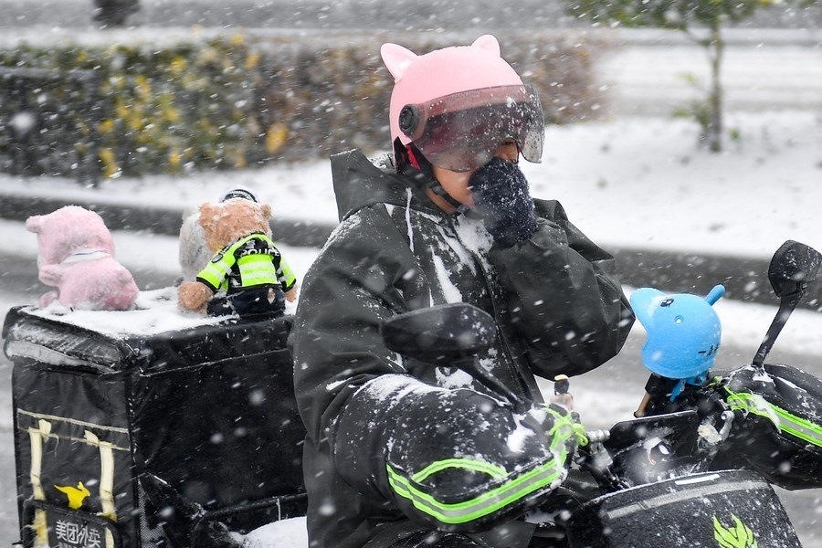 11月6日，在長春市街頭，一名外賣員在雪中騎行。新華社記者 許暢 攝