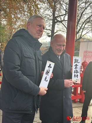 柏林市長韋格納（右）、動(dòng)物園監(jiān)事會(huì)主席布魯克曼（左）手持中國文化中心工作人員現(xiàn)場手書的中文名字。人民網(wǎng)記者 徐馨攝