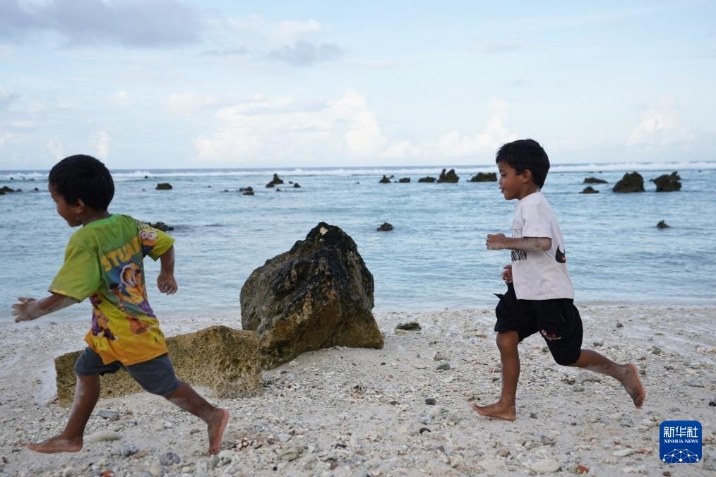 1月20日，兒童在瑙魯海邊嬉戲。新華社記者 王申 攝
