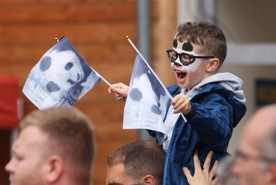  2023年7月26日，在法國(guó)圣艾尼昂市博瓦勒野生動(dòng)物園外，一名兒童等待送別熊貓“圓夢(mèng)”。新華社記者 高靜 攝