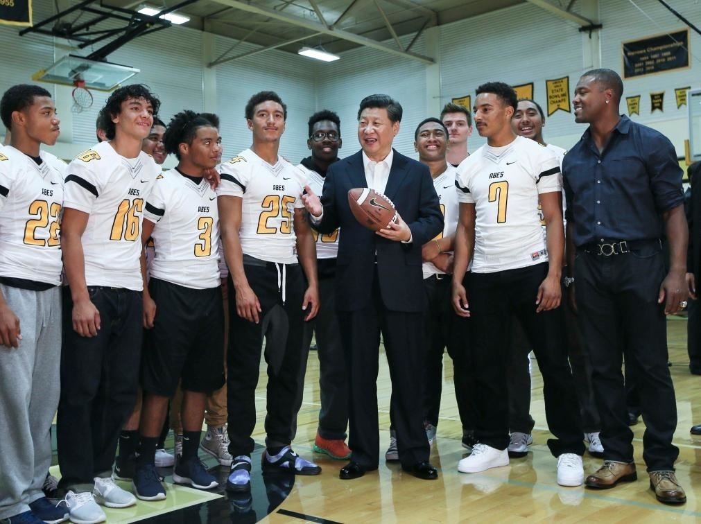 2015年9月23日，國家主席習(xí)近平參觀美國塔科馬市林肯中學(xué)。這是習(xí)近平在學(xué)校體育館，同上橄欖球訓(xùn)練課的學(xué)生們親切交談。新華社記者 蘭紅光 攝