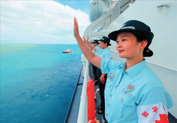 中國海軍“和平方舟”號醫(yī)院船結束訪問湯加時，任務官兵中的文職人員向歡送人群揮手告別（2023年8月4日攝）。徐巍攝/本刊