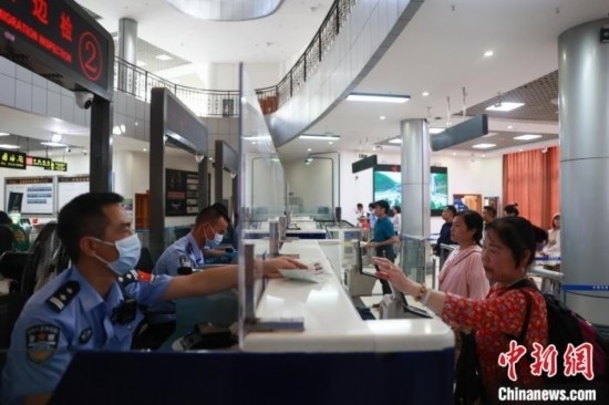 圖為旅客在磨憨口岸辦理通關(guān)手續(xù)。雷雨 攝