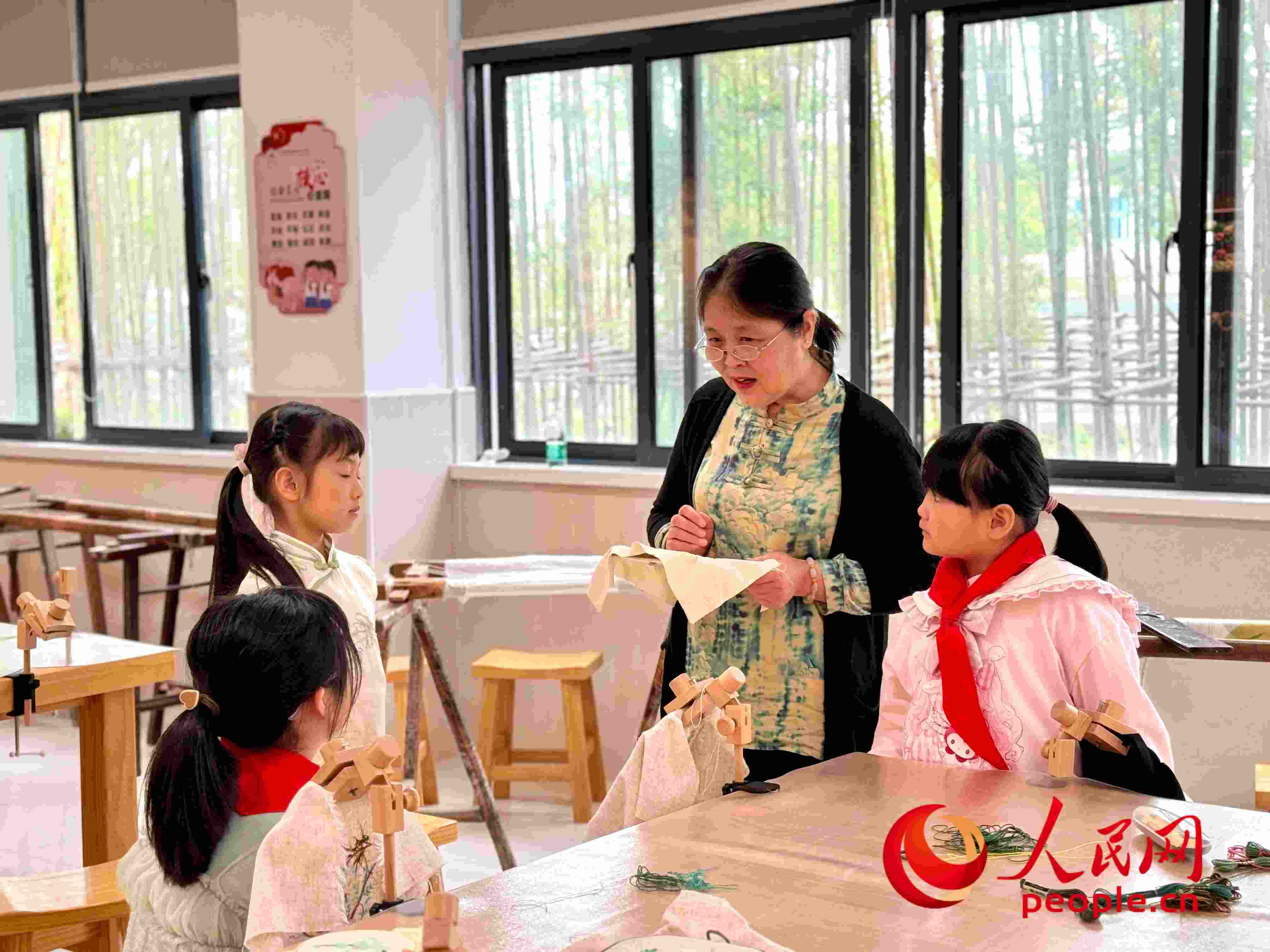 顧建珍（左三）在教孩子們刺繡知識(shí)。人民網(wǎng) 周靜圓攝