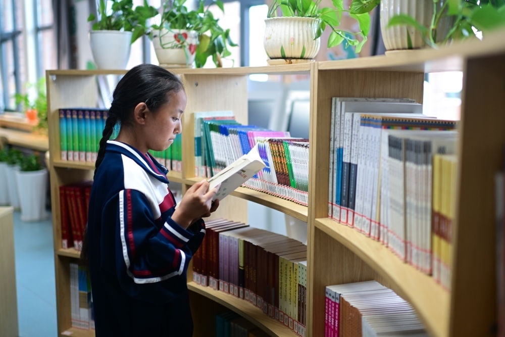6月18日，果洛西寧民族中學(xué)學(xué)生尼東拉毛在圖書室看書。