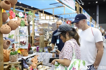 游客在蘭納博覽會(huì)特色展位上選購(gòu)工藝品。人民網(wǎng)記者楊一攝