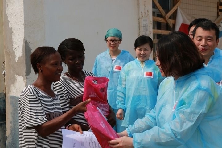 2015年4月4日，在位于塞拉利昂首都弗里敦市郊的中塞友好醫(yī)院埃博拉診療中心，中國第四批援塞醫(yī)療隊(duì)副隊(duì)長邵蔚（右前）向被治愈的埃博拉出血熱患者贈(zèng)送禮物。新華社發(fā)（祖榮強(qiáng) 攝）