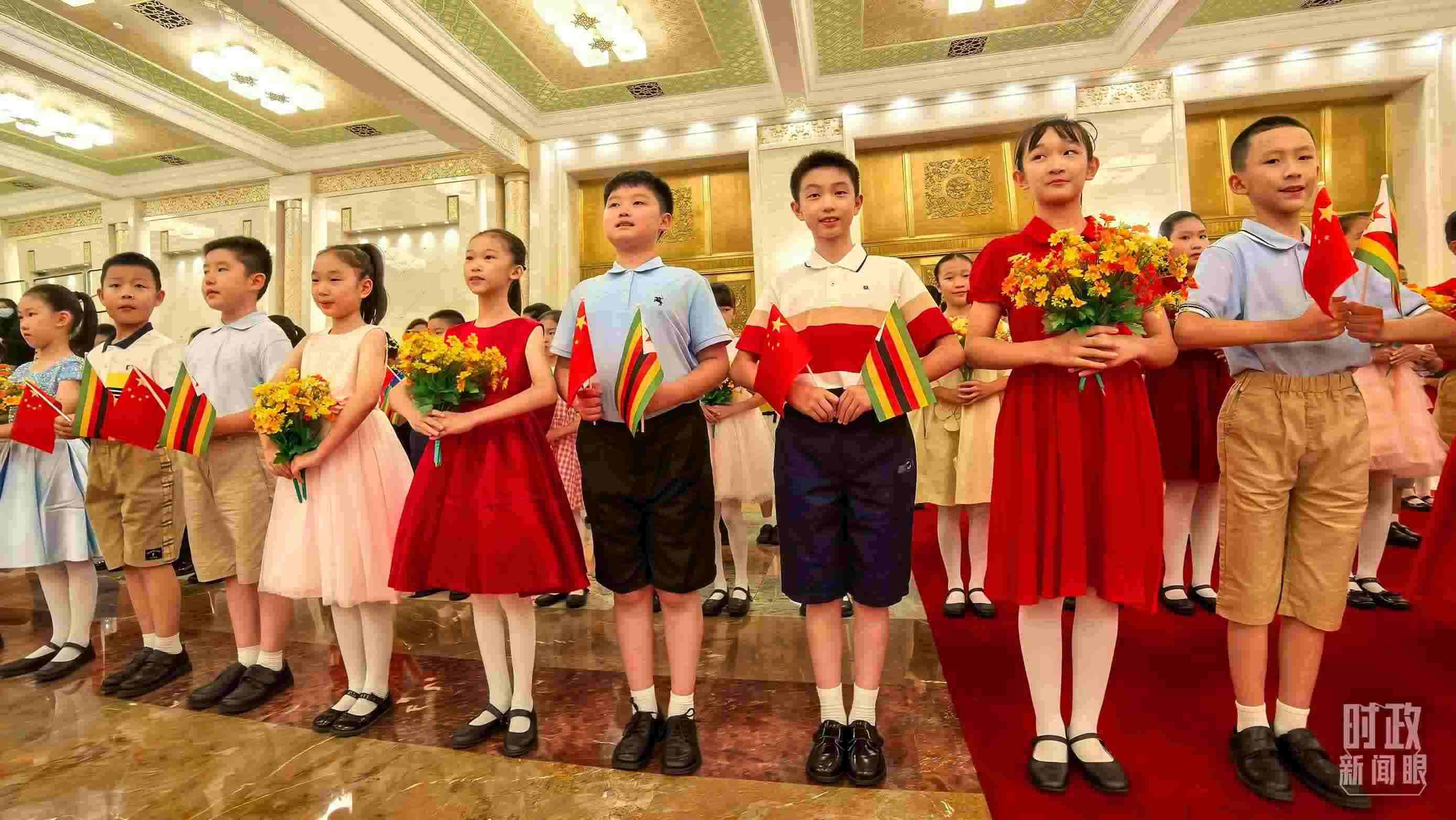 △現(xiàn)場歡迎津巴布韋總統(tǒng)訪華的青少年。（總臺央視記者鐘銳拍攝）