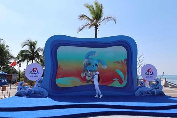 第12棒火炬手“點(diǎn)燃”現(xiàn)場大屏幕上運(yùn)動(dòng)會(huì)吉祥物“吉貝”手中的火炬。主辦方供圖