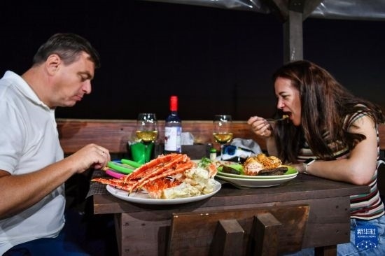 9月2日，食客們在俄羅斯符拉迪沃斯托克的一家餐館品嘗帝王蟹。新華社記者 曹陽 攝