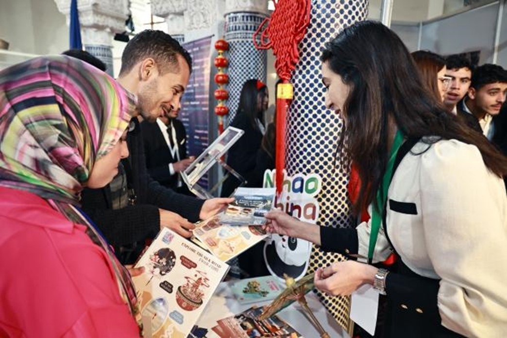 摩洛哥觀眾在中國展臺前觀看宣傳資料。拉巴特中國文化中心供圖