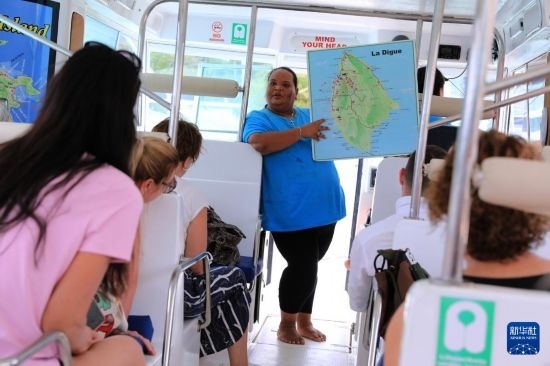 3月15日，一名導(dǎo)游在游艇上為游客介紹塞舌爾拉迪格島。新華社記者 董江輝 攝